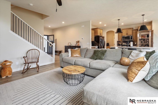 9601 S 184th Ter, Omaha, NE 68136 - living area with arched walkways, recessed lighting, light wood-style floors, stairs, and ceiling fan