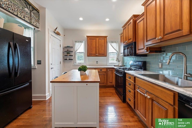 816 S 49th St, Omaha, NE 68106 - kitchen featuring black appliances, a sink, wooden counters, brown cabinetry, and wood finished floors