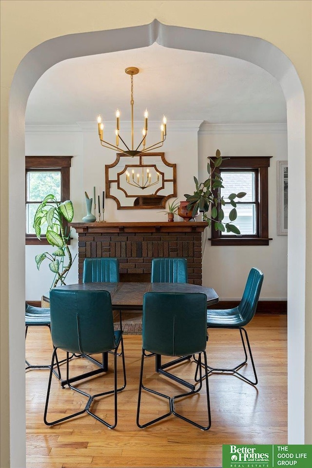 816 S 49th St, Omaha, NE 68106 - dining area with arched walkways, ornamental molding, wood finished floors, and a chandelier
