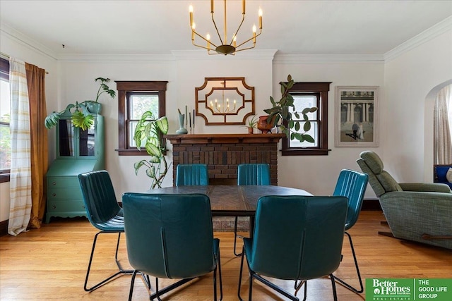 816 S 49th St, Omaha, NE 68106 - dining room featuring a chandelier, light wood-type flooring, arched walkways, and crown molding