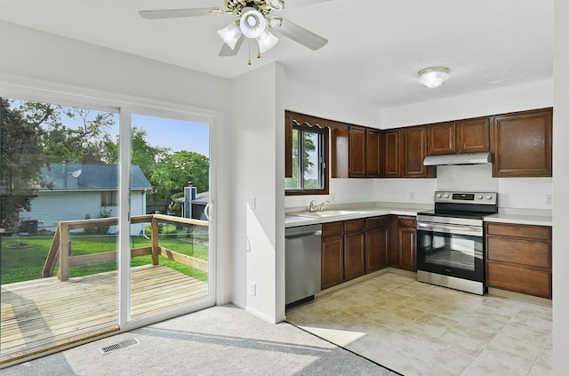13304 S 21st St, Bellevue, NE 68123 - kitchen with stainless steel appliances, under cabinet range hood, light countertops, a ceiling fan, and dark brown cabinetry