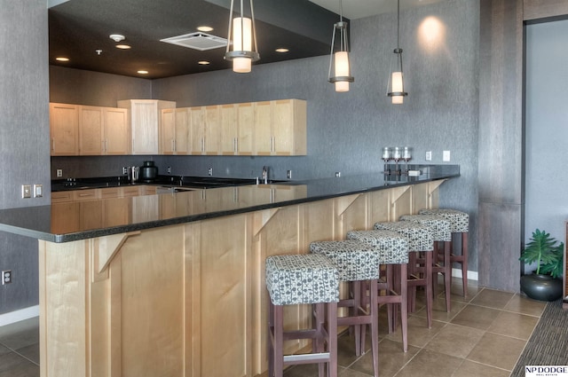 3200 Farnam Ct Unit 3604, Omaha, NE 68131 - kitchen with light brown cabinets, dark countertops, a kitchen breakfast bar, and light tile patterned flooring
