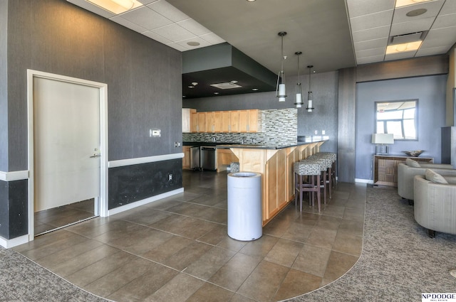3200 Farnam Ct Unit 3604, Omaha, NE 68131 - kitchen featuring a drop ceiling, a kitchen breakfast bar, dark countertops, baseboards, and dishwasher