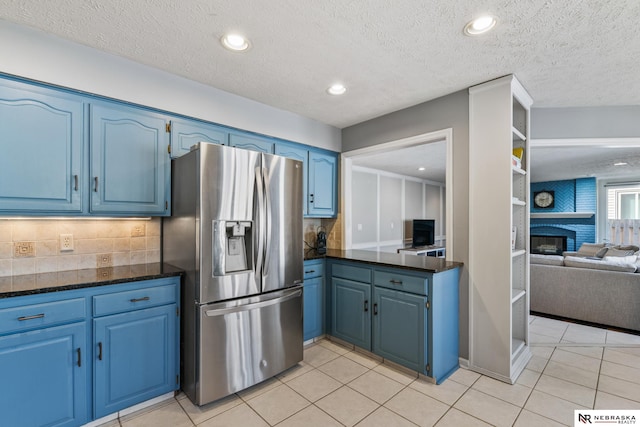 716 N 148th St, Omaha, NE 68154 - kitchen featuring stainless steel fridge, blue cabinetry, light tile patterned flooring, backsplash, and recessed lighting