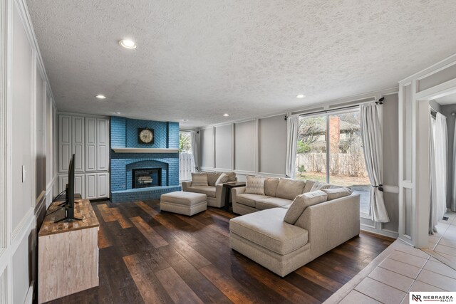 716 N 148th St, Omaha, NE 68154 - living area with a decorative wall, a textured ceiling, ornamental molding, recessed lighting, and a brick fireplace