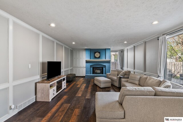 716 N 148th St, Omaha, NE 68154 - living room featuring a decorative wall, a textured ceiling, dark wood-style flooring, plenty of natural light, and recessed lighting