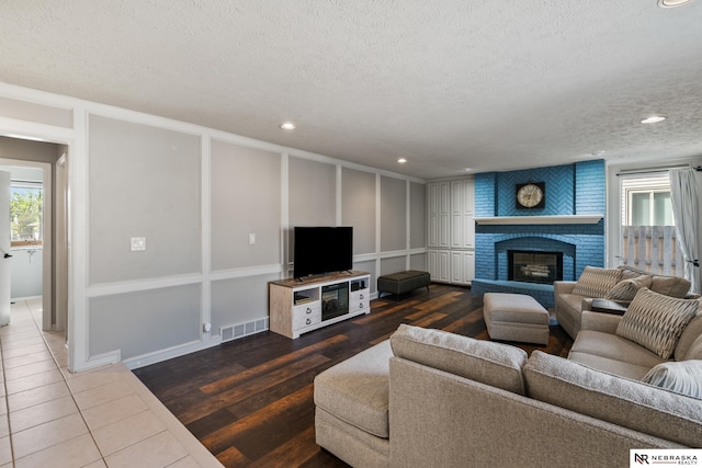 716 N 148th St, Omaha, NE 68154 - living room featuring a textured ceiling, plenty of natural light, wood finished floors, a fireplace, and recessed lighting