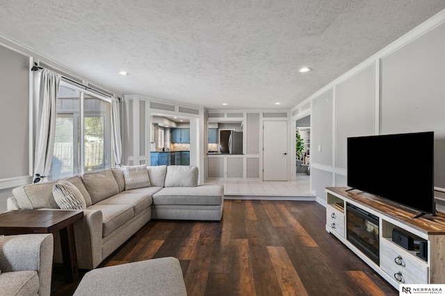716 N 148th St, Omaha, NE 68154 - living area featuring a textured ceiling, a decorative wall, ornamental molding, dark wood-type flooring, and recessed lighting