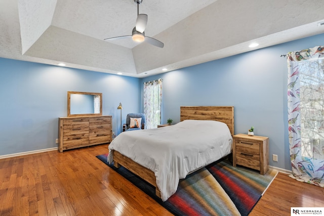 716 N 148th St, Omaha, NE 68154 - bedroom featuring a tray ceiling, wood finished floors, baseboards, and a ceiling fan