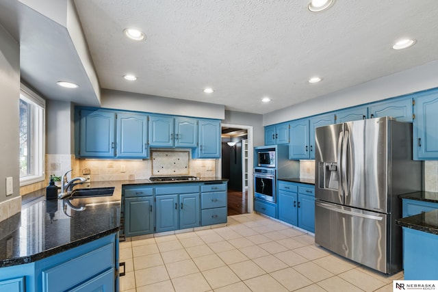 716 N 148th St, Omaha, NE 68154 - kitchen featuring stainless steel appliances, blue cabinets, a sink, a textured ceiling, and recessed lighting
