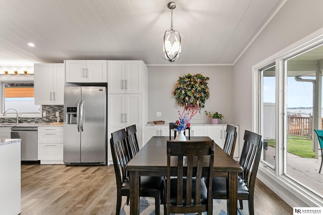 112 W Lakeshore Dr, Lincoln, NE 68528 - dining area with crown molding, light wood-style flooring, recessed lighting, and a chandelier