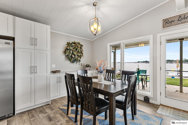 112 W Lakeshore Dr, Lincoln, NE 68528 - dining room with a chandelier, light wood-type flooring, healthy amount of natural light, ornamental molding, and lofted ceiling