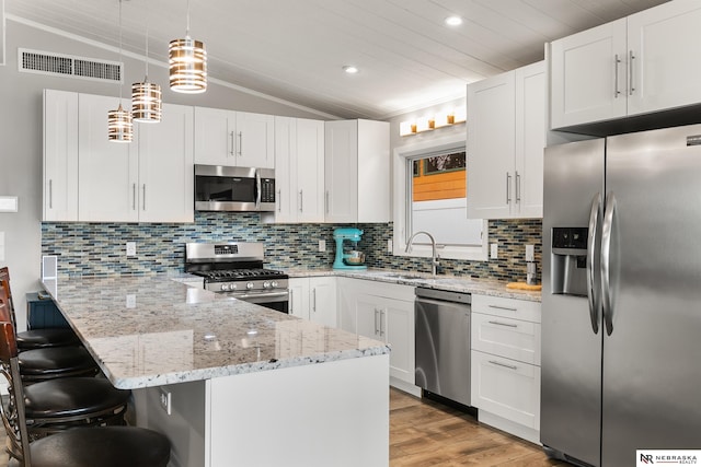 112 W Lakeshore Dr, Lincoln, NE 68528 - kitchen with appliances with stainless steel finishes, a sink, lofted ceiling, a peninsula, and light wood-type flooring