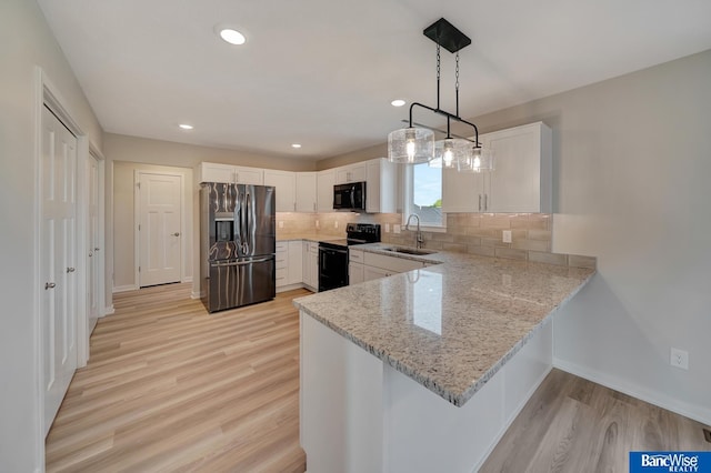 3556 Pearl Crescent Dr, Lincoln, NE 68504 - kitchen featuring black appliances, a sink, a peninsula, light wood-style floors, and white cabinets