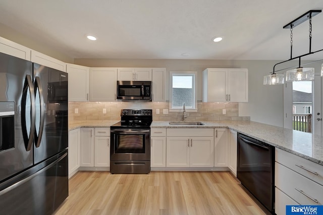 3556 Pearl Crescent Dr, Lincoln, NE 68504 - kitchen with stainless steel appliances, a sink, light wood finished floors, white cabinets, and recessed lighting