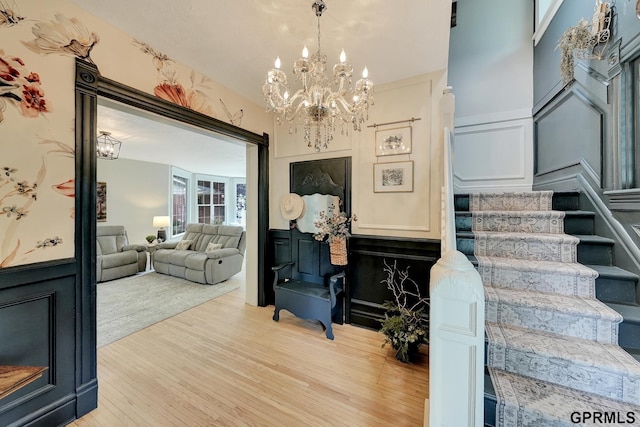 149 N 1st St, Seward, NE 68434 - living room with a chandelier, light wood-style floors, stairs, a decorative wall, and wainscoting