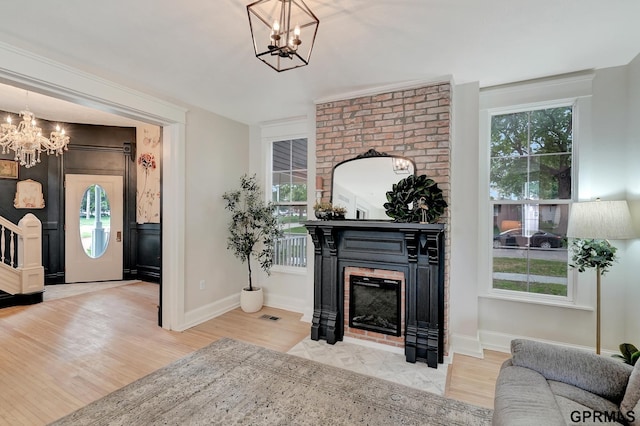 149 N 1st St, Seward, NE 68434 - living room with a chandelier, wood finished floors, a brick fireplace, and baseboards