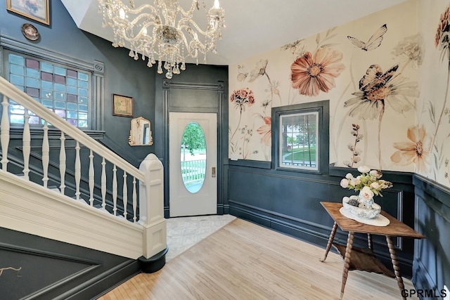 149 N 1st St, Seward, NE 68434 - entrance foyer with a chandelier, wood finished floors, stairs, and a wainscoted wall