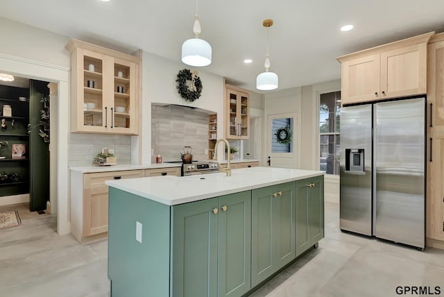 149 N 1st St, Seward, NE 68434 - kitchen with appliances with stainless steel finishes, green cabinetry, tasteful backsplash, light countertops, and an island with sink