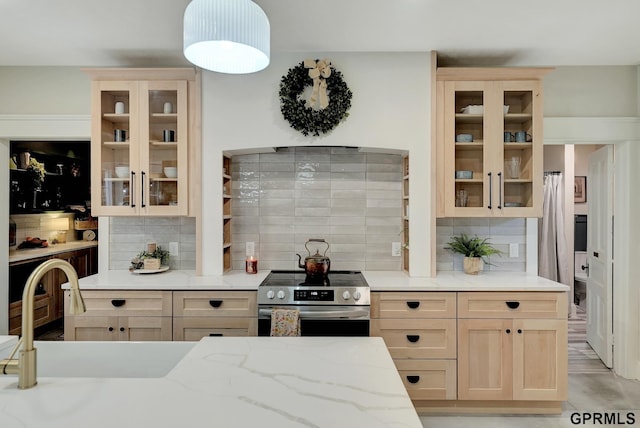 149 N 1st St, Seward, NE 68434 - kitchen with stainless steel electric stove, tasteful backsplash, a sink, and light stone counters