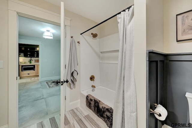 149 N 1st St, Seward, NE 68434 - bathroom featuring shower / bath combo with shower curtain, toilet, and baseboards