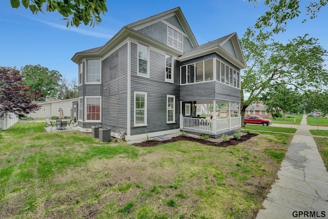 149 N 1st St, Seward, NE 68434 - view of side of home featuring a patio area, a yard, cooling unit, and a sunroom