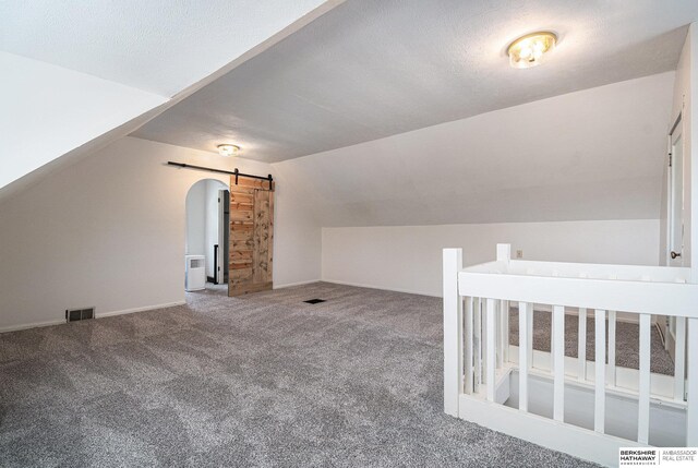 4427 Pine St, Omaha, NE 68105 - bonus room with a barn door, carpet flooring, vaulted ceiling, and baseboards