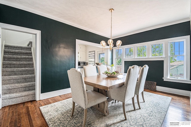 4427 Pine St, Omaha, NE 68105 - dining room with stairs, a chandelier, baseboards, and wood finished floors