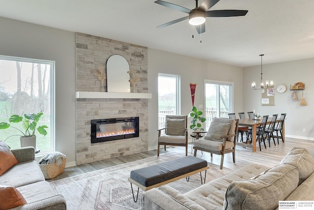 8622 N 177th St, Bennington, NE 68007 - living area featuring a stone fireplace, ceiling fan, wood finished floors, a chandelier, and baseboards