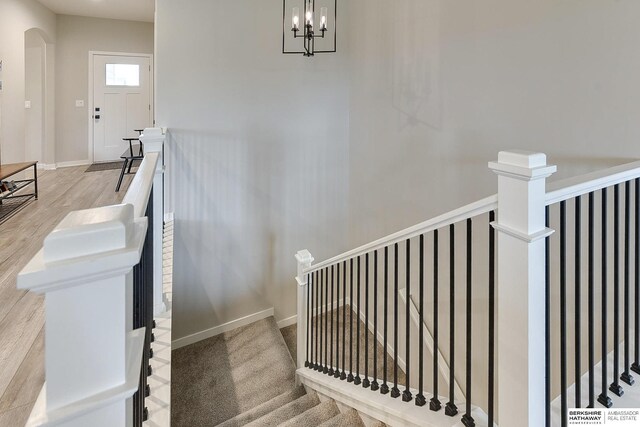 8622 N 177th St, Bennington, NE 68007 - stairway with a chandelier, arched walkways, wood finished floors, and baseboards