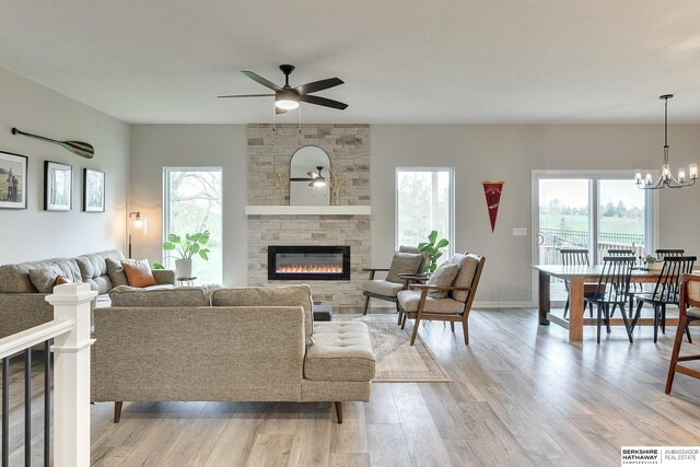 8622 N 177th St, Bennington, NE 68007 - living room with a stone fireplace, ceiling fan, healthy amount of natural light, and light wood finished floors