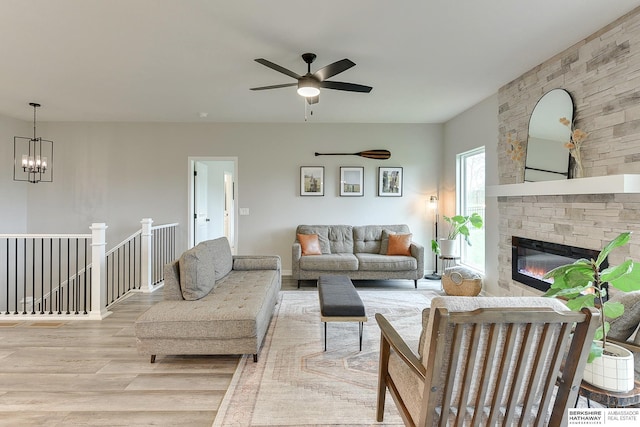 8622 N 177th St, Bennington, NE 68007 - living area with wood finished floors, a ceiling fan, a stone fireplace, and a chandelier