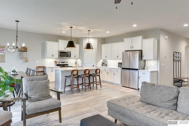 8622 N 177th St, Bennington, NE 68007 - living area featuring recessed lighting, light wood-style floors, a chandelier, and ceiling fan