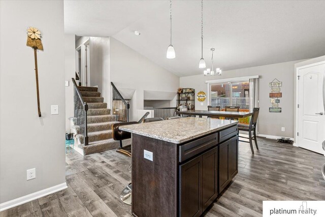 7784 N 88th Ave, Omaha, NE 68122 - kitchen with dark brown cabinets, a center island, dark wood finished floors, decorative light fixtures, and vaulted ceiling