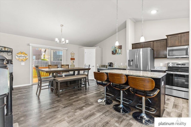 7784 N 88th Ave, Omaha, NE 68122 - kitchen featuring stainless steel appliances, dark brown cabinets, a kitchen island, a chandelier, and light stone counters