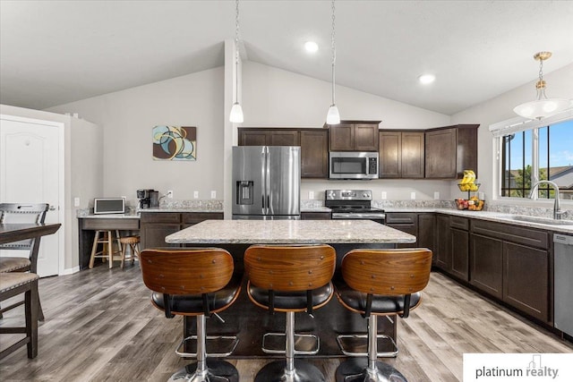 7784 N 88th Ave, Omaha, NE 68122 - kitchen featuring appliances with stainless steel finishes, lofted ceiling, dark brown cabinets, a kitchen island, and hanging light fixtures