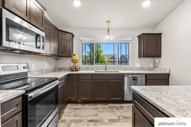 7784 N 88th Ave, Omaha, NE 68122 - kitchen with appliances with stainless steel finishes, light wood finished floors, dark brown cabinetry, hanging light fixtures, and recessed lighting