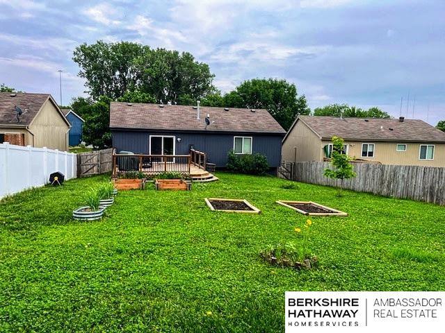 7628 Bondesson St, Omaha, NE 68122 - back of property with a vegetable garden and a deck