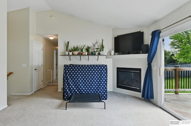 7628 Bondesson St, Omaha, NE 68122 - carpeted living room featuring lofted ceiling, a glass covered fireplace, and baseboards
