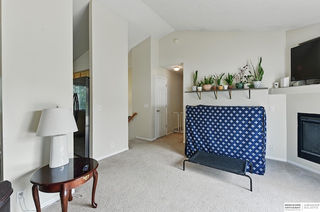 7628 Bondesson St, Omaha, NE 68122 - carpeted living area featuring vaulted ceiling, a glass covered fireplace, and baseboards