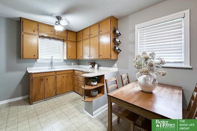 3869 Arbor St, Omaha, NE 68105 - kitchen featuring a sink, light countertops, baseboards, ceiling fan, and plenty of natural light