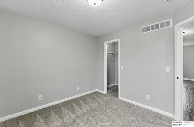8925 N 159th Ave, Bennington, NE 68007 - unfurnished bedroom featuring baseboards, carpet, a spacious closet, a textured ceiling, and a closet