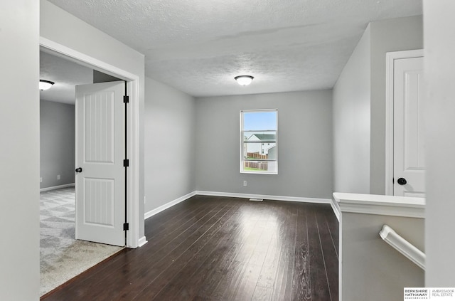 8925 N 159th Ave, Bennington, NE 68007 - spare room featuring dark wood-style flooring, baseboards, and a textured ceiling