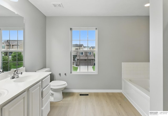 8925 N 159th Ave, Bennington, NE 68007 - bathroom featuring wood finished floors, double vanity, toilet, and healthy amount of natural light