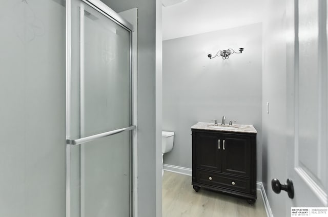 8925 N 159th Ave, Bennington, NE 68007 - full bathroom featuring wood finished floors, toilet, a shower with door, baseboards, and vanity