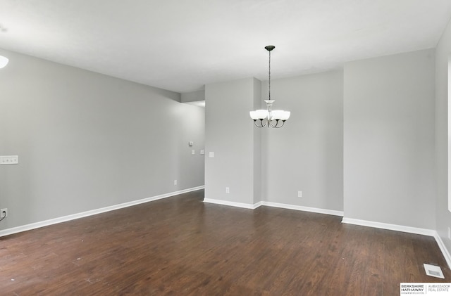 8925 N 159th Ave, Bennington, NE 68007 - empty room featuring baseboards, dark wood-style floors, and a chandelier