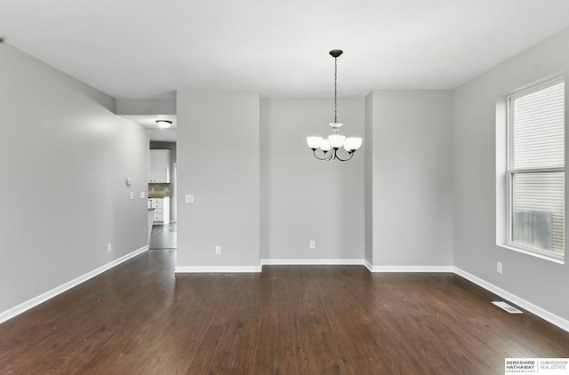 8925 N 159th Ave, Bennington, NE 68007 - empty room featuring dark wood-style flooring, a chandelier, and baseboards