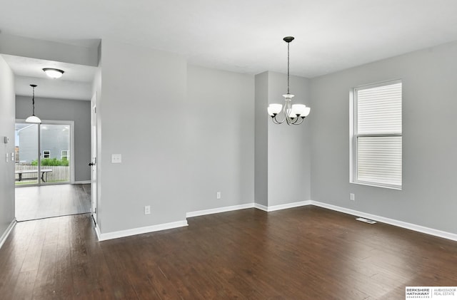 8925 N 159th Ave, Bennington, NE 68007 - spare room featuring a chandelier, dark wood-style flooring, and baseboards