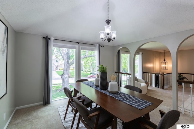 15461 Harney St, Omaha, NE 68154 - dining room featuring light carpet, a chandelier, arched walkways, a textured ceiling, and baseboards