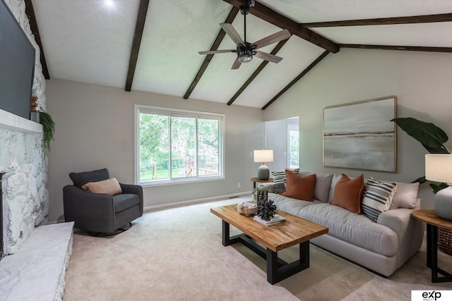 15461 Harney St, Omaha, NE 68154 - carpeted living area featuring ceiling fan, beamed ceiling, a stone fireplace, high vaulted ceiling, and baseboards